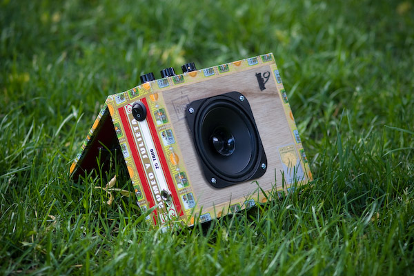 The amp on the grass, propped open with the speaker facing the camera