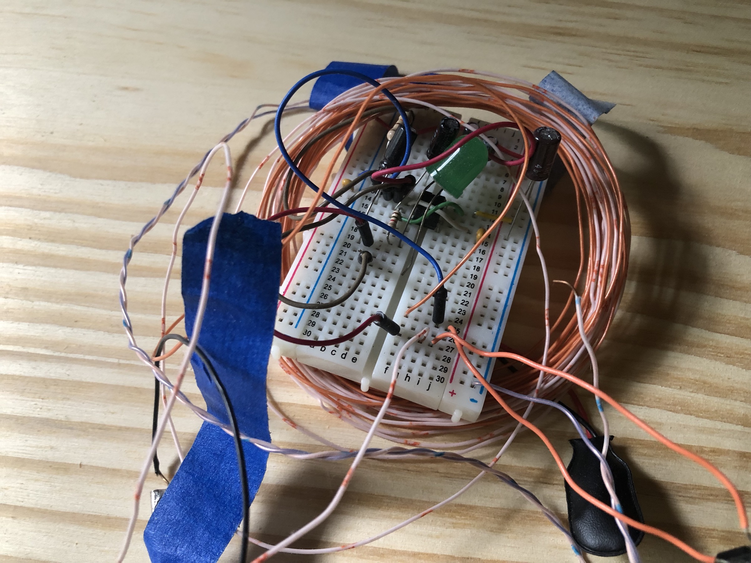 A circuit on a breadboard with wires everywhere, and a big, loosely coiled bit of wire going around the whole thing