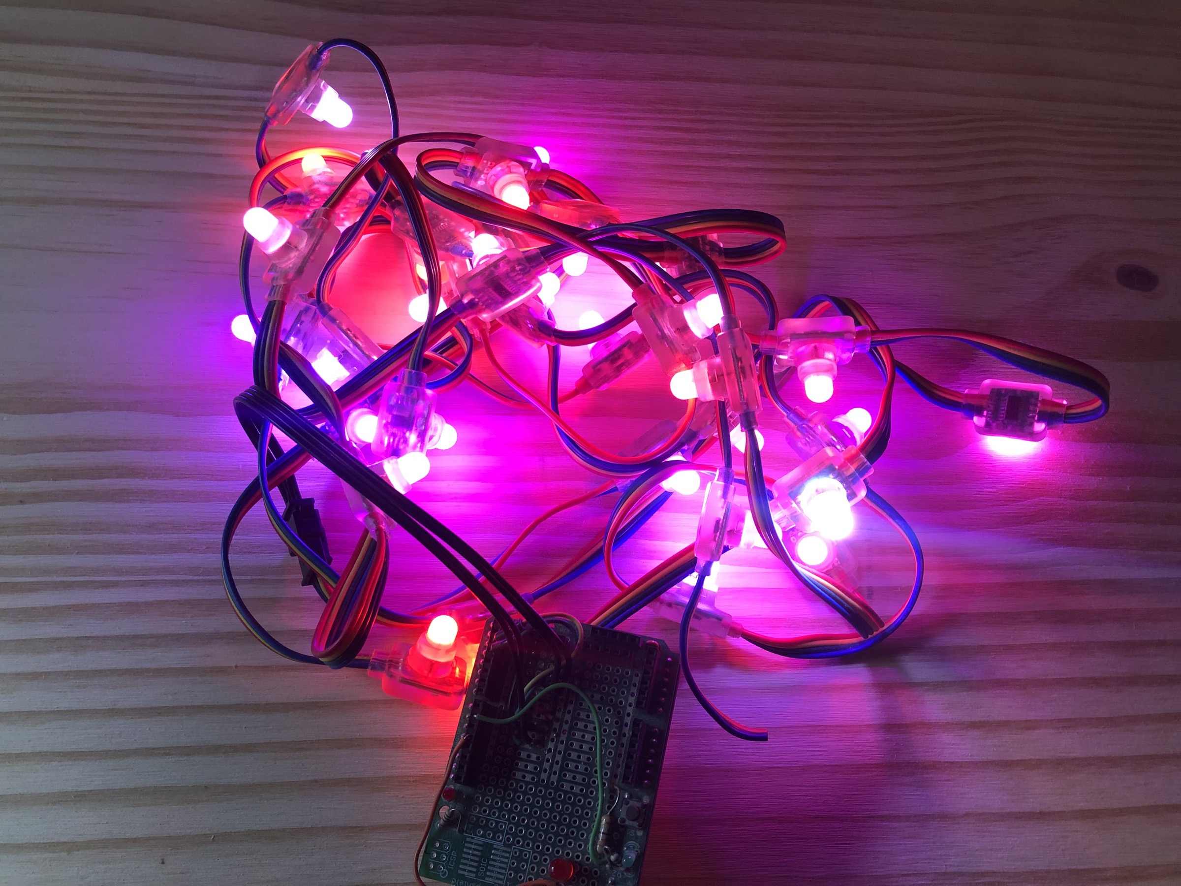 A heap of wired LEDs, all displaying a color ranging from white, to pink, to red, to purple, and everything in between.